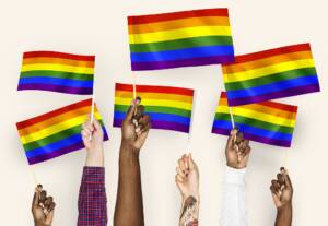 LGBTQ therapist - hands waving LGBTQ flags